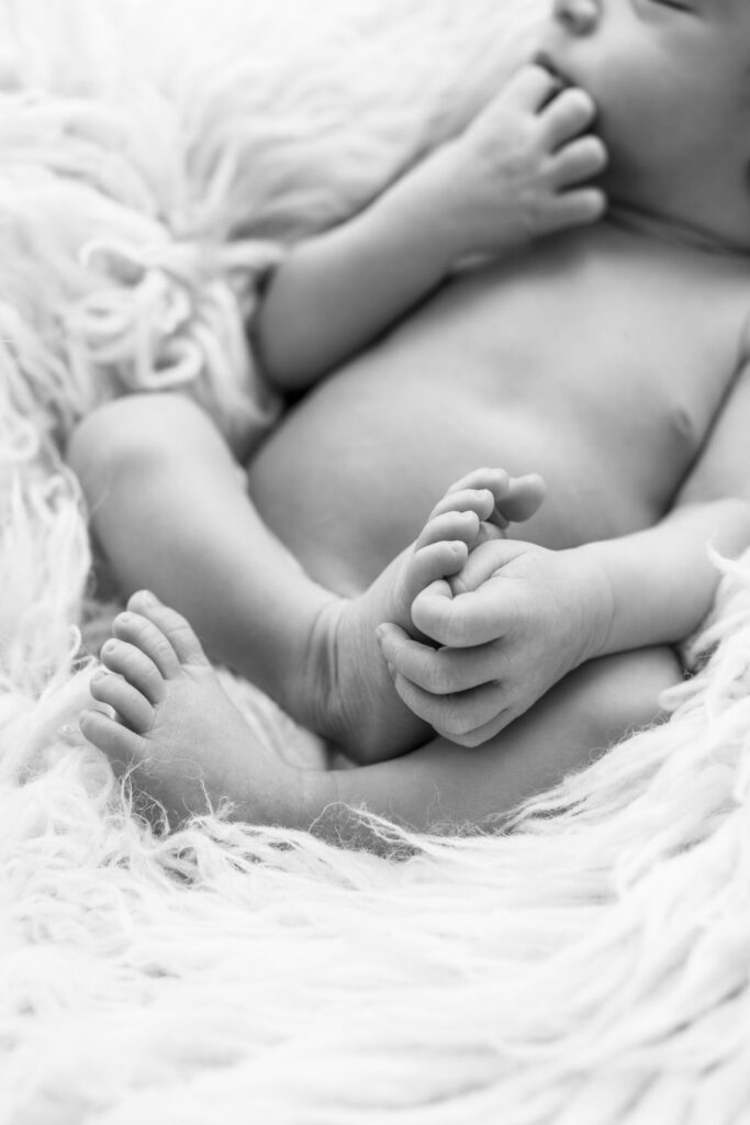 Minimalistische Neugeborenenfotos mit Fokus auf den kleinen Babyhfüßen